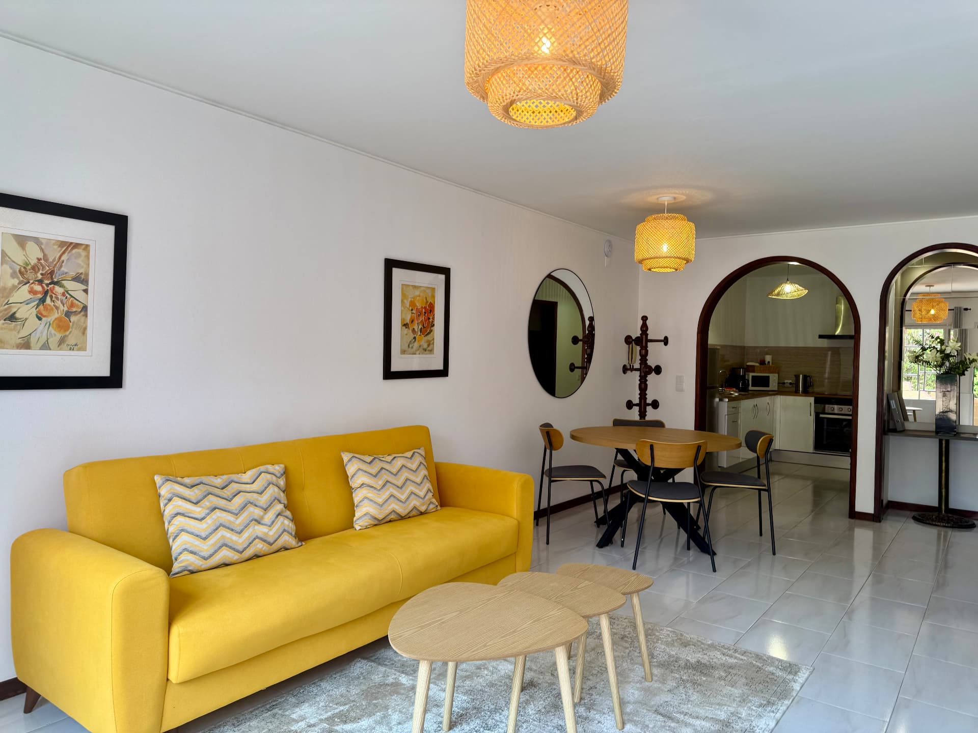 Comfort Villa open-plan living and dining area with yellow sofa, nesting tables and arched kitchen doorway