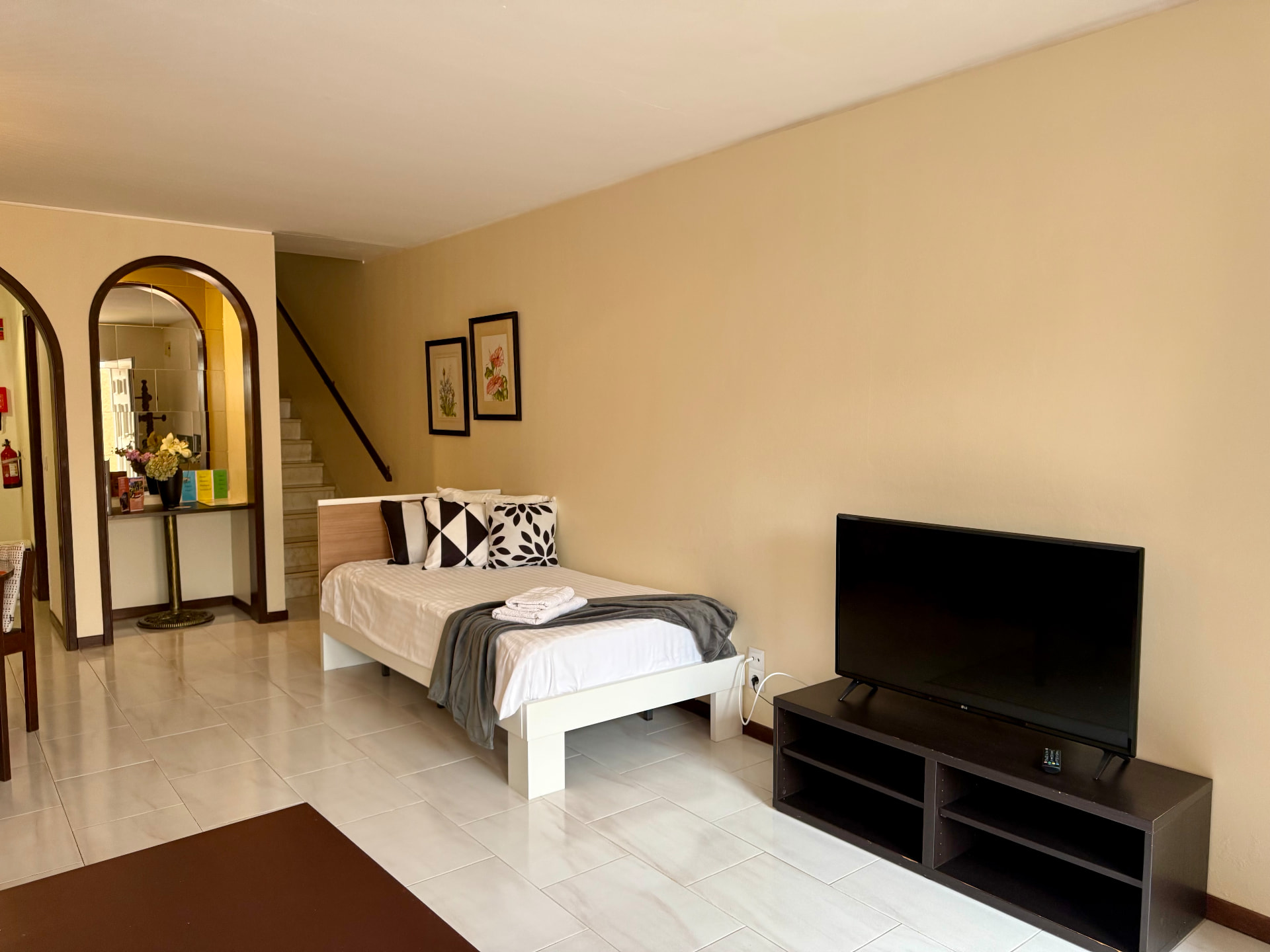 Family Villa bedroom with single bed, patterned pillows and television