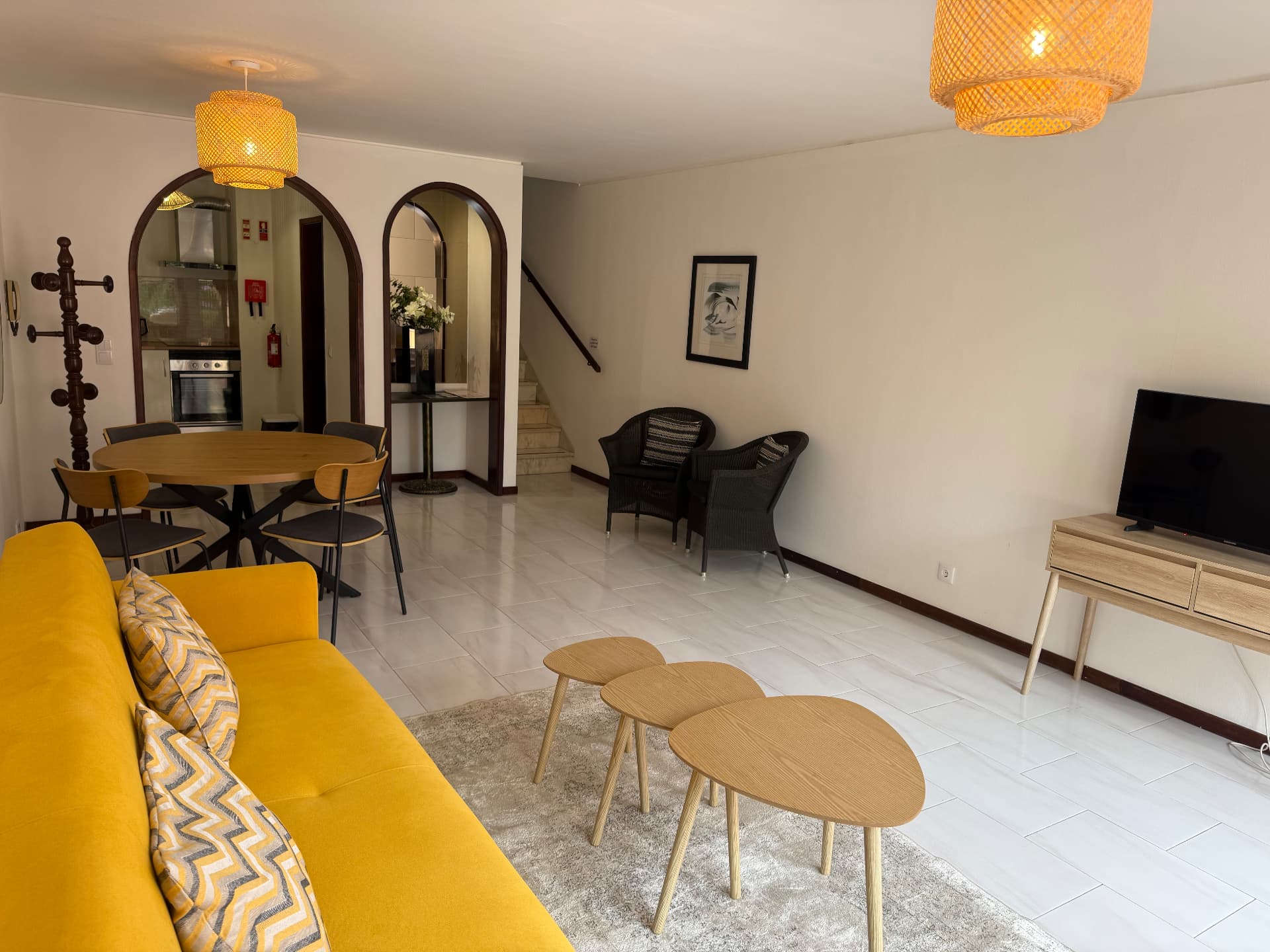 Comfort Villa open-plan living and dining area showing both archways, yellow sofa and round dining table